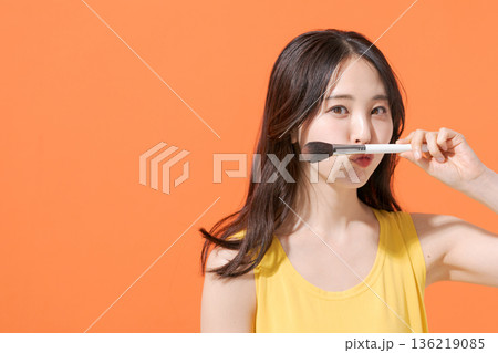 メイクブラシを持つ笑顔の女性 136219085