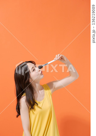 メイクブラシを持つ笑顔の女性 メイクブラシを持つ笑顔の女性 136219089