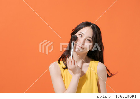 メイクブラシを持つ笑顔の女性 メイクブラシを持つ笑顔の女性 136219091