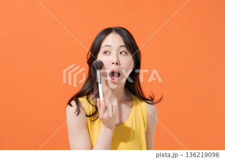 メイクブラシを持つ笑顔の女性 メイクブラシを持つ笑顔の女性 136219096