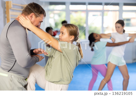 Coach and girl training self-defense techniques 136219105