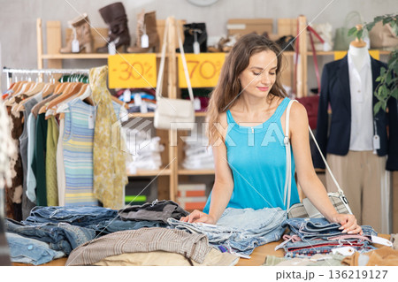 Young woman on sale choosing jeans Young woman on sale choosing jeans 136219127