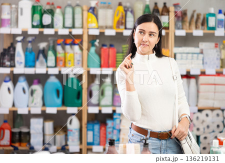 woman chooses household chemicals in a supermarket woman chooses household chemicals in a supermarket 136219131
