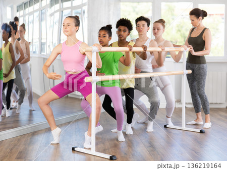 Teenage girl practicing plie position of ballet during choreography classes 136219164