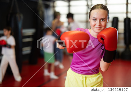 Teenage girl in boxing gloves in training 136219197