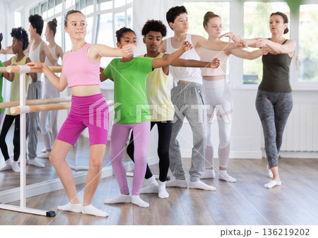Teenage girl practicing plie position of ballet during choreography classes 136219202