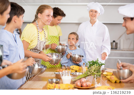 Chef apprentices learn how to properly beat eggs with a whisk in cooking class Chef apprentices learn how to properly beat eggs with a whisk in cooking class 136219239