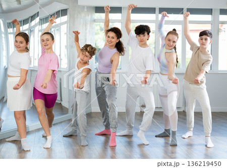 Girls and boys teens stand with female teacher in choreographic ballroom. 136219450