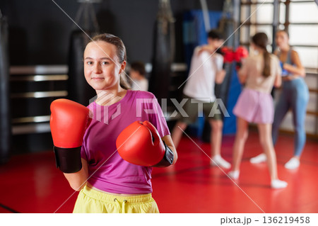 Teenage girl in boxing gloves in training 136219458