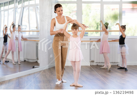 Woman teacher corrects movement of girl dancer 136219498
