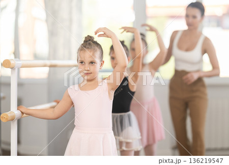 Woman teacher corrects girls in batman tandu movement Woman teacher corrects girls in batman tandu movement 136219547