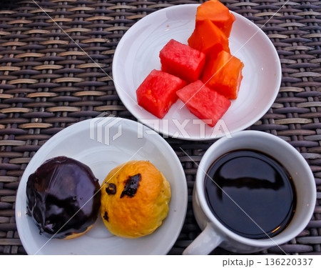 close up photo of a cup of bitter black coffee and a bread snack 136220337