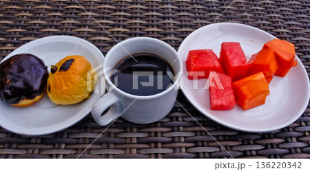 close up photo of a cup of bitter black coffee and a bread snack close up photo of a cup of bitter black coffee and a bread snack 136220342