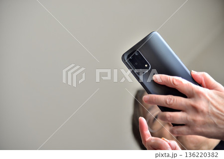 携帯電話を操作するシニア女性 136220382