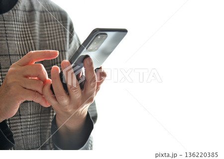 携帯電話を操作するシニア女性 携帯電話を操作するシニア女性 136220385