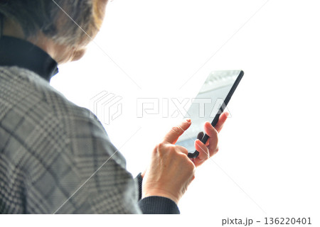 携帯電話を操作するシニア女性 136220401