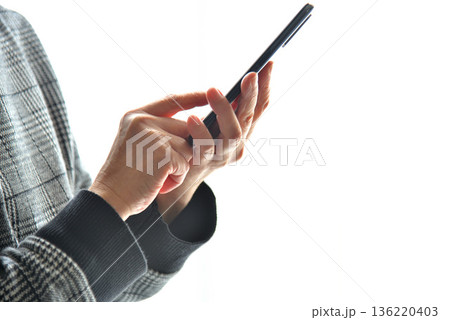 携帯電話を操作するシニア女性 携帯電話を操作するシニア女性 136220403