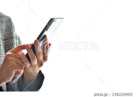 携帯電話を操作するシニア女性 136220405