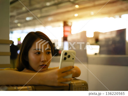 空港でスマホ操作する女性 ■撮影協力：関西国際空港（KIX） 136220565