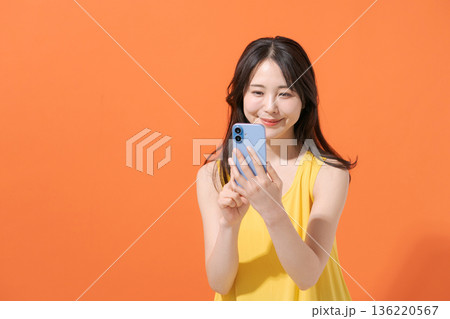 スマホを持つ笑顔の女性 136220567