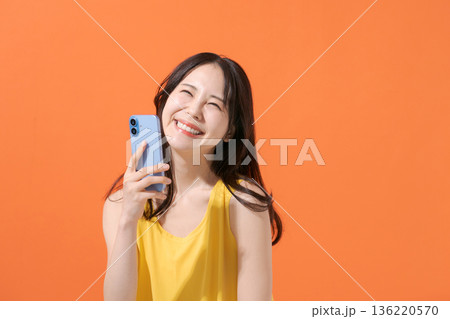 スマホを持つ笑顔の女性 スマホを持つ笑顔の女性 136220570