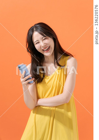 スマホを持つ笑顔の女性 136220576