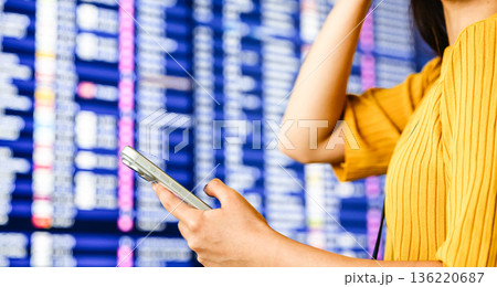 空港で情報確認する女性 ■撮影協力：関西国際空港（KIX） 136220687