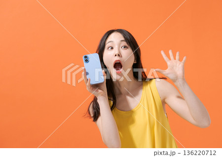 スマホを持つ驚いた表情の女性 スマホを持つ驚いた表情の女性 136220712