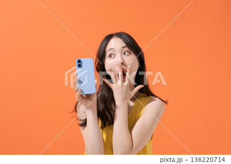 スマホを持つ驚いた表情の女性 スマホを持つ驚いた表情の女性 136220714