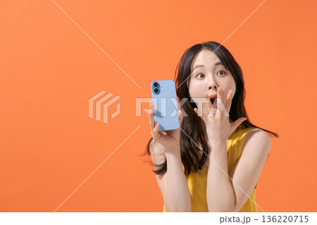 スマホを持つ驚いた表情の女性 スマホを持つ驚いた表情の女性 136220715