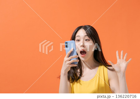 スマホを持つ驚いた表情の女性 スマホを持つ驚いた表情の女性 136220716
