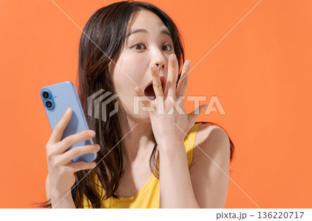スマホを持つ驚いた表情の女性 スマホを持つ驚いた表情の女性 136220717