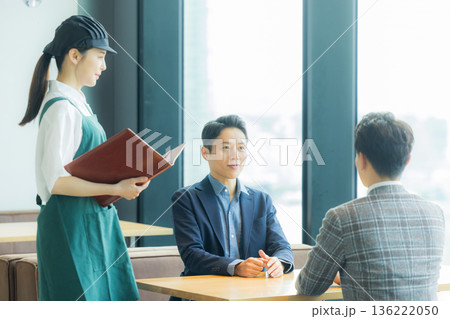 カフェで注文をとるスタッフ 136222050