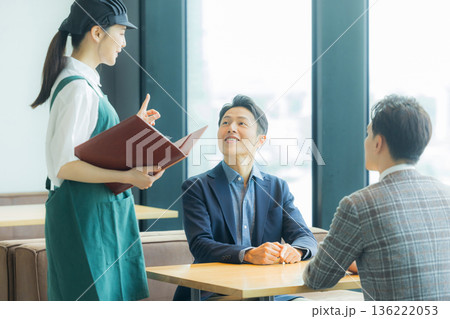 カフェで注文をとるスタッフ 136222053