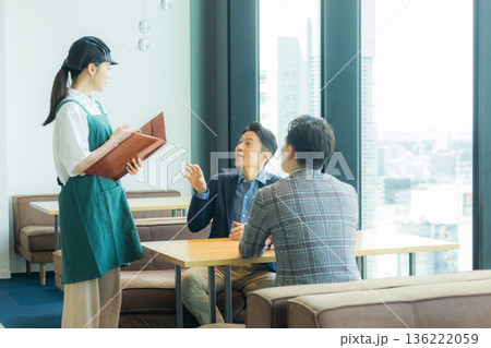 カフェで注文をとるスタッフ 136222059