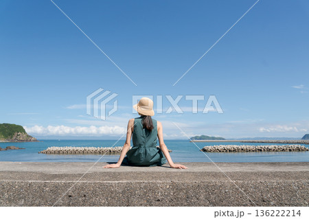 防波堤に座る女性 136222214