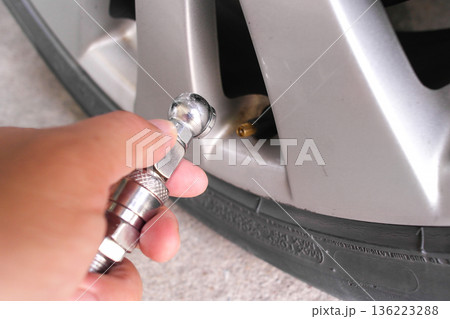 Inflating a car tire with tire air chuck Inflating a car tire with tire air chuck 136223288