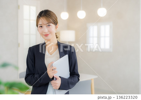 ファイルを持ったスーツの女性 136223320