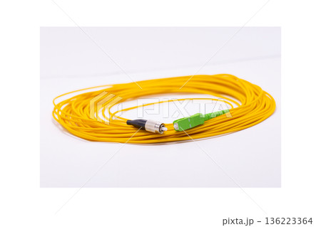 Yellow fiber optic cable rolled on white background, long network cable for data and internet connection 136223364
