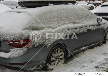 Lviv Ukraine 01.01.26 Snow covers a parked car in a winter city street during daytime Lviv Ukraine 01.01.26 Snow covers a parked car in a winter city street during daytime 136223685