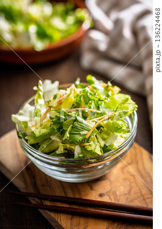 Mix of fresh green salad with carrot in bowl on wooden table. Mix of fresh green salad with carrot in bowl on wooden table. 136224468