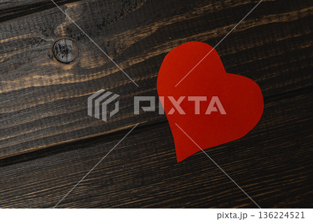 Heart shape cut from paper placed on wooden surface 136224521