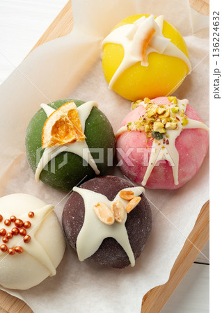 Colorful sweet treats displayed on a wooden board with simple decoration Colorful sweet treats displayed on a wooden board with simple decoration 136224632