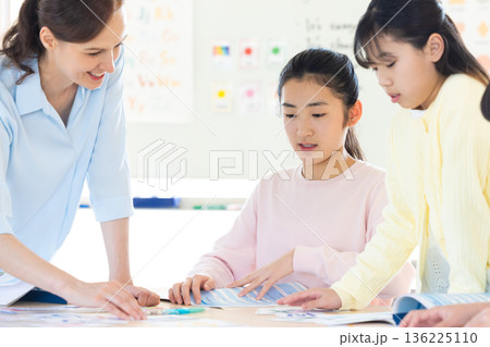 教育　英会話教室でレッスンを受ける子供とネイティブ講師 136225110