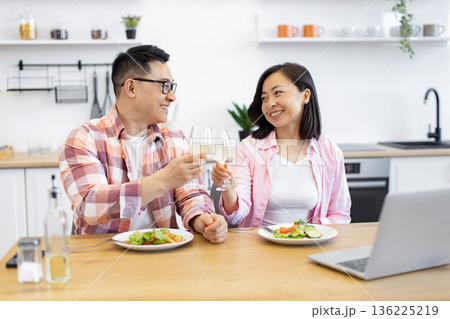 An Asian couple enjoys a meal and wine together at home, celebrating a special occasion An Asian couple enjoys a meal and wine together at home, celebrating a special occasion 136225219