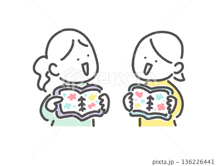 シール帳を使ってシール交換を楽しむ2人の女性 見せ合う シール帳を使ってシール交換を楽しむ2人の女性 見せ合う 136226441