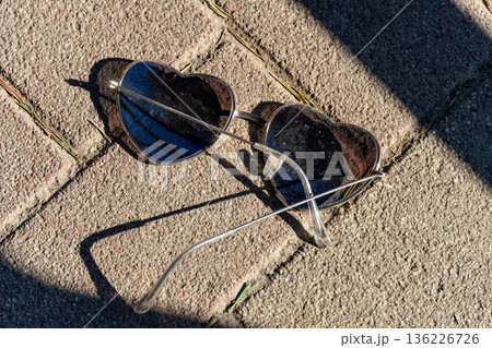 日差しの強い路面に落ちているサングラス 136226726