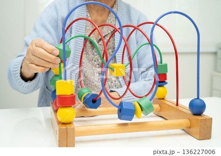 Asian elderly woman playing enhancing skill board game. Asian elderly woman playing enhancing skill board game. 136227006