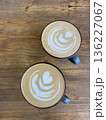 Top view of two beautifully crafted lattes with heart latte art on a wooden table, perfect for cafe or coffee themes.  136227067