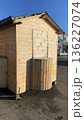 A small wooden booth or kiosk with a curved outdoor counter, closed and unstaffed, in an open paved area.  136227074